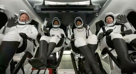 En esta imagen del video de SpaceX, los pasajeros a bordo de una cápsula SpaceX reaccionan cuando la cápsula se lanza en paracaídas hacia el Atlántico frente a la costa de Florida el 18 de septiembre de 2021.  La tripulación de aficionados fue la primera en dar la vuelta al mundo sin un astronauta profesional.  (SpaceX a través de AP)