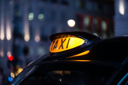 Cerrar imagen de la señal de taxi iluminada en un taxi londinense en Piccadilly Circus.